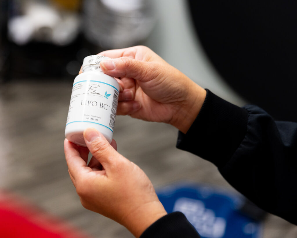 A woman's hands holding Lipo-BC supplement, which was recommended by a weight loss specialist near Half Moon, NC.
