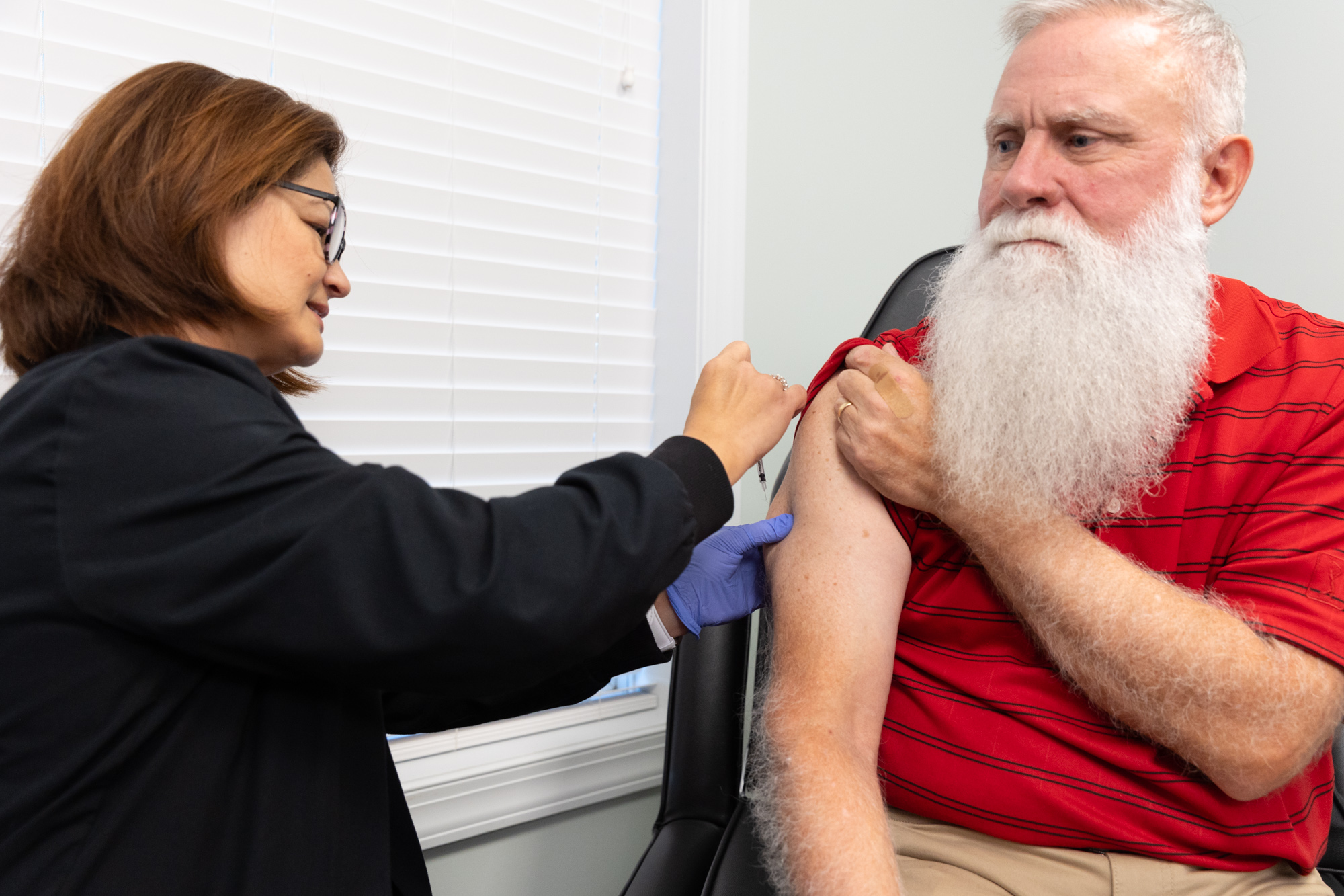 Man pulls shirt sleeve up while medical provider injects his arm with semaglutide, an option for medical weight loss in Jacksonville, NC